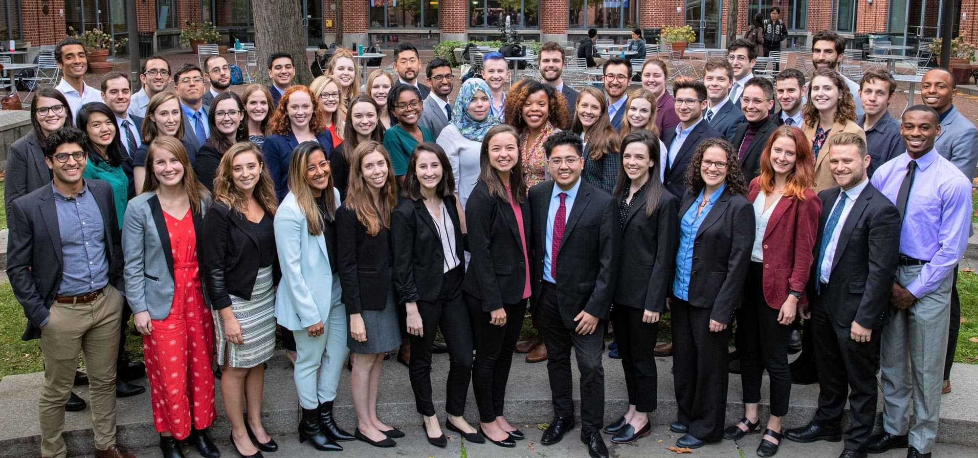 Penn Carey Law students dressed in casual business attire in a smile for a large outdoor group photo
